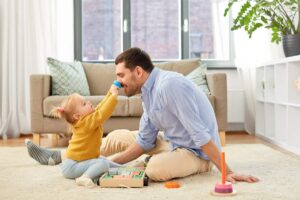 Daddy's playing with his daughter.
