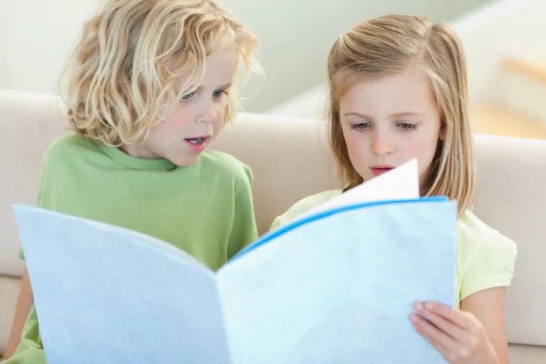 Bilingual children reading a book / Freepik
