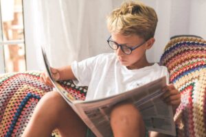 A boy reading a newspaper.