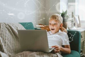 The boy is surprised sitting at his laptop / Freepik