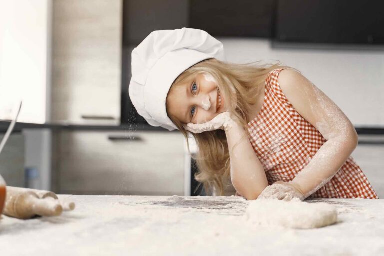 A little girl makes a pie. A child in the kitchen. A child with flour / Pexels