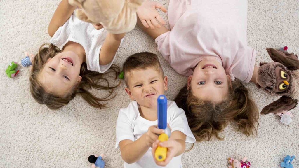 A boy and two girls lying on the floor / Freepik
