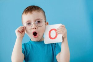 Boy pronounces the letter O / Freepik