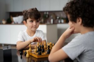 Два мальчика играют в шахматы / Freepik