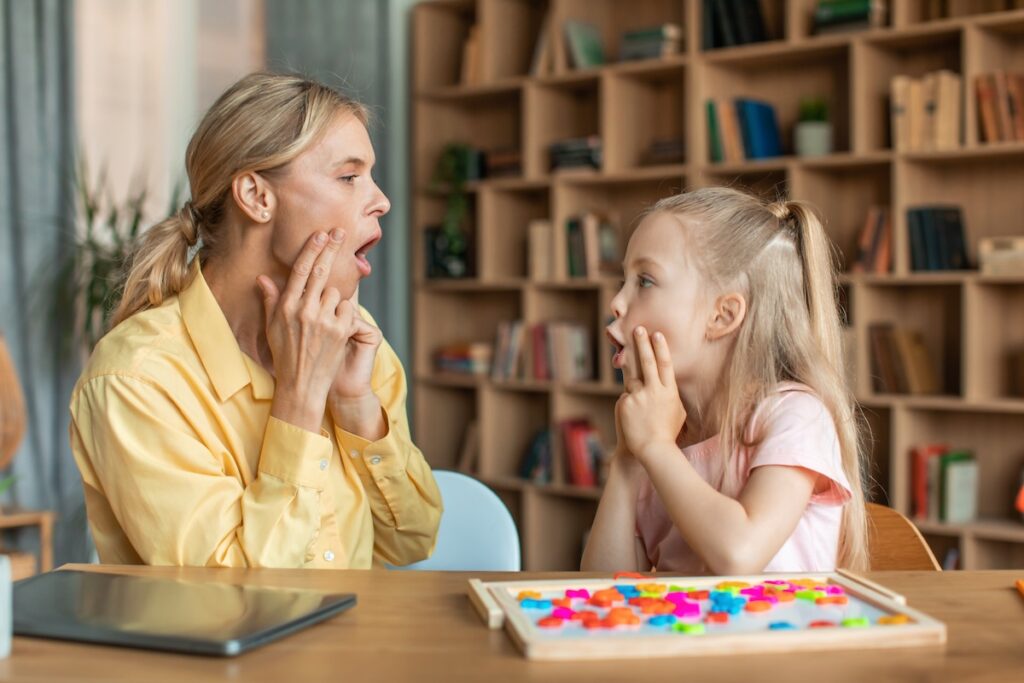 A woman engages in speech with a girl