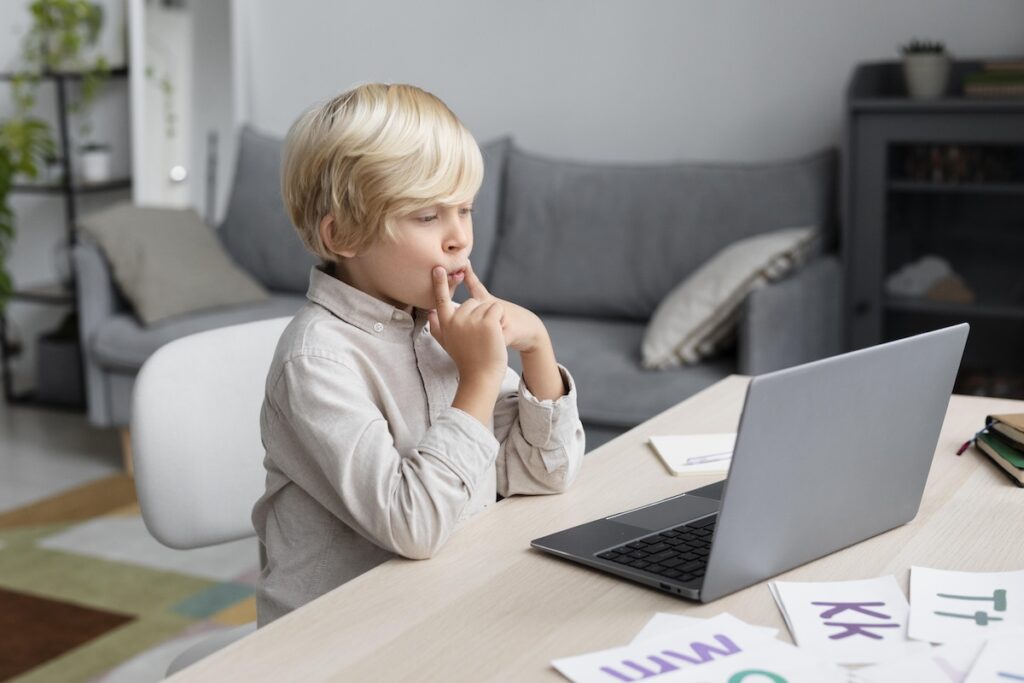 Ребенок занимается постановкой речью за ноутбуком онлайн