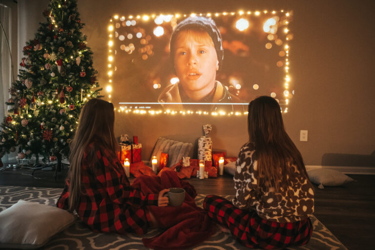 Beautiful teenage girls watching a Christmas movie on Christmas Eve. High quality photo.