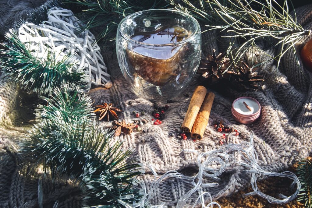 Уютный рождественский фон со специями и декоративными деталями на вязаном фоне.