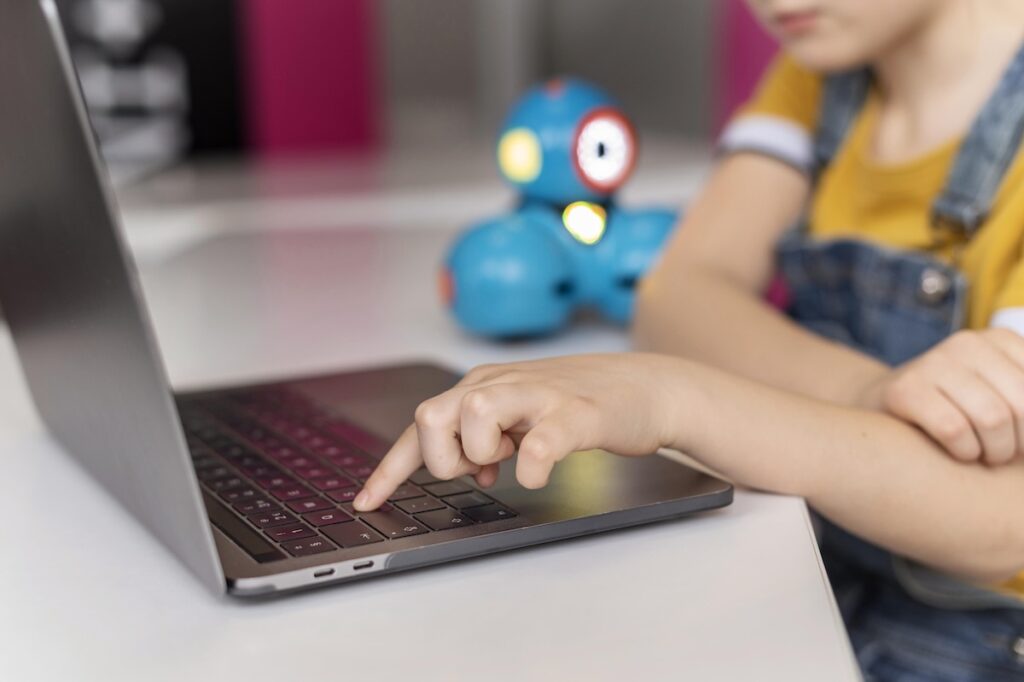 Ребенок нажимает на клавишу ноутбука