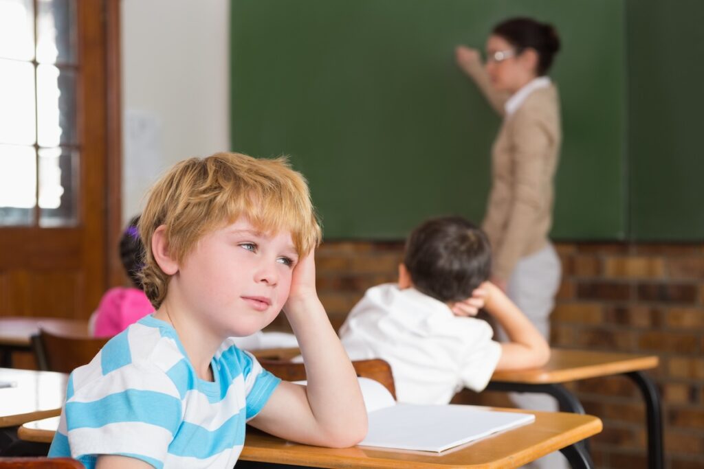 A young student is inattentive in an elementary school class.
