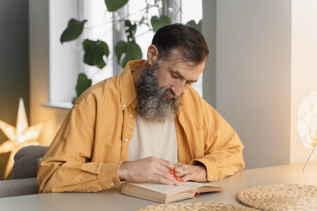 Мужчина с бородой читает книгу