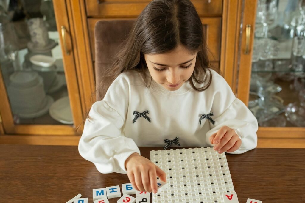 Девочка за столом учит русский язык