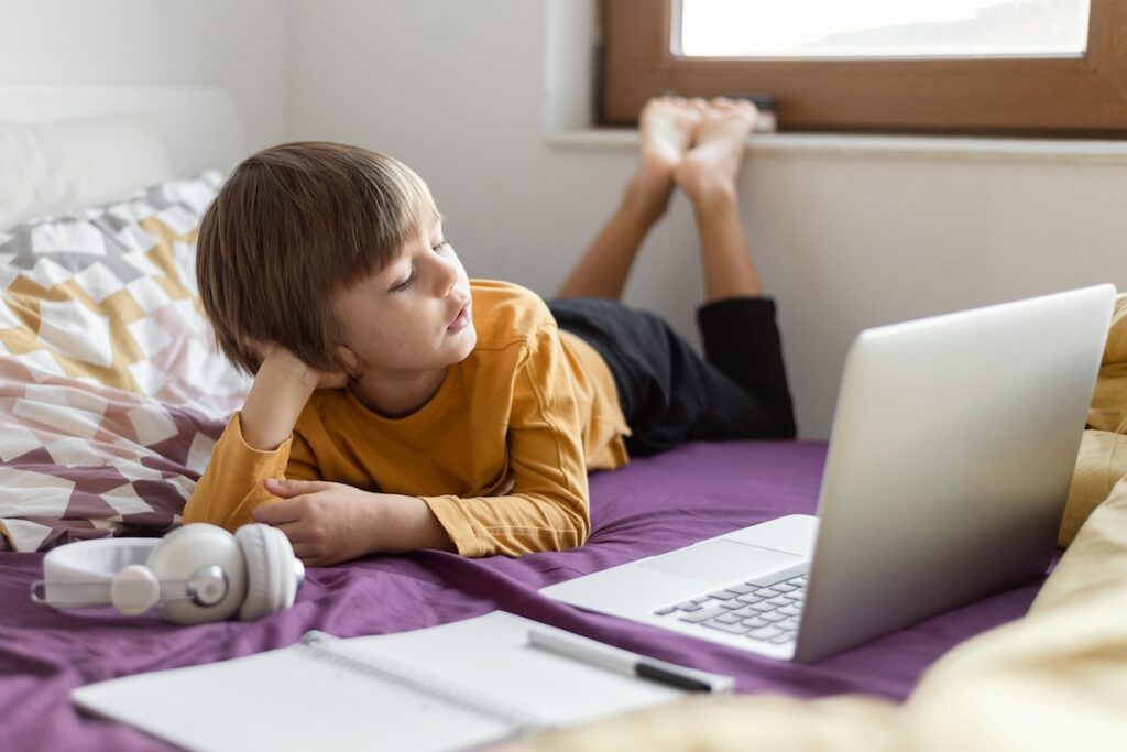 The child learns online lying on the bed
