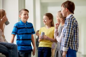 A group of high school students with soda cans in the hallway