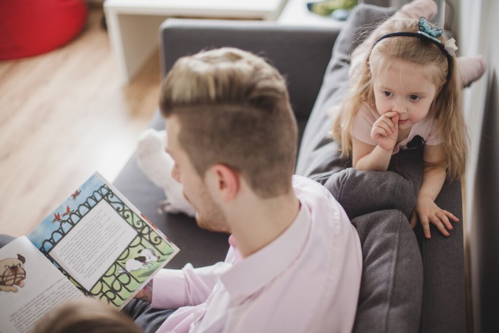 Daddy's reading a book to his daughter