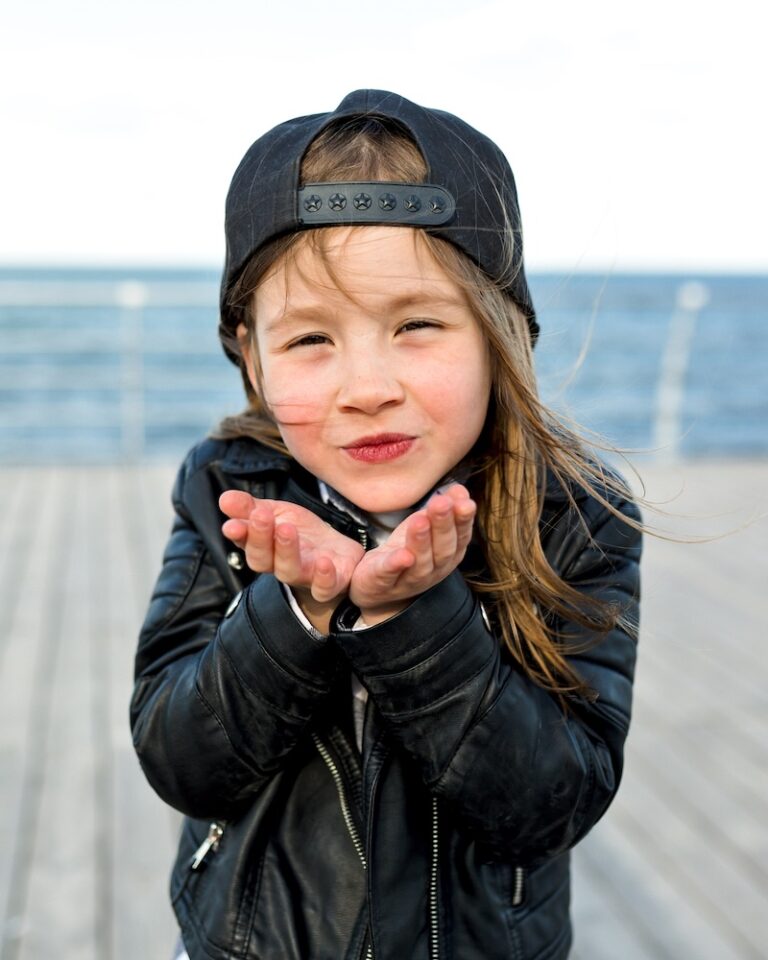 очаровательная-милая-маленькая-девочка-в-стильной-куртке-кепке-посылает-поцелуй