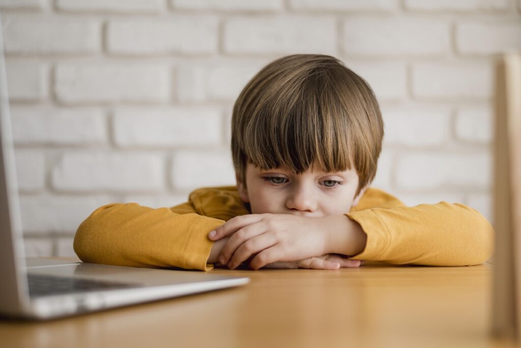 Ребенок грустит за ноутбуком