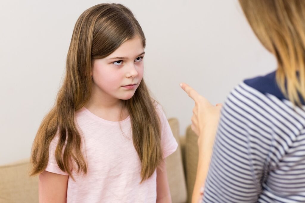 A mother scolds her daughter in the living room of the house.