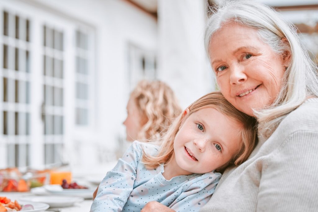 Семья, обед и портрет девочки с бабушкой в знак любви, поддержки и празднования праздника. Счастливый ребенок и расслабление в объятиях женщины, еда для поддержания здоровья, благодарность и забота о доме.