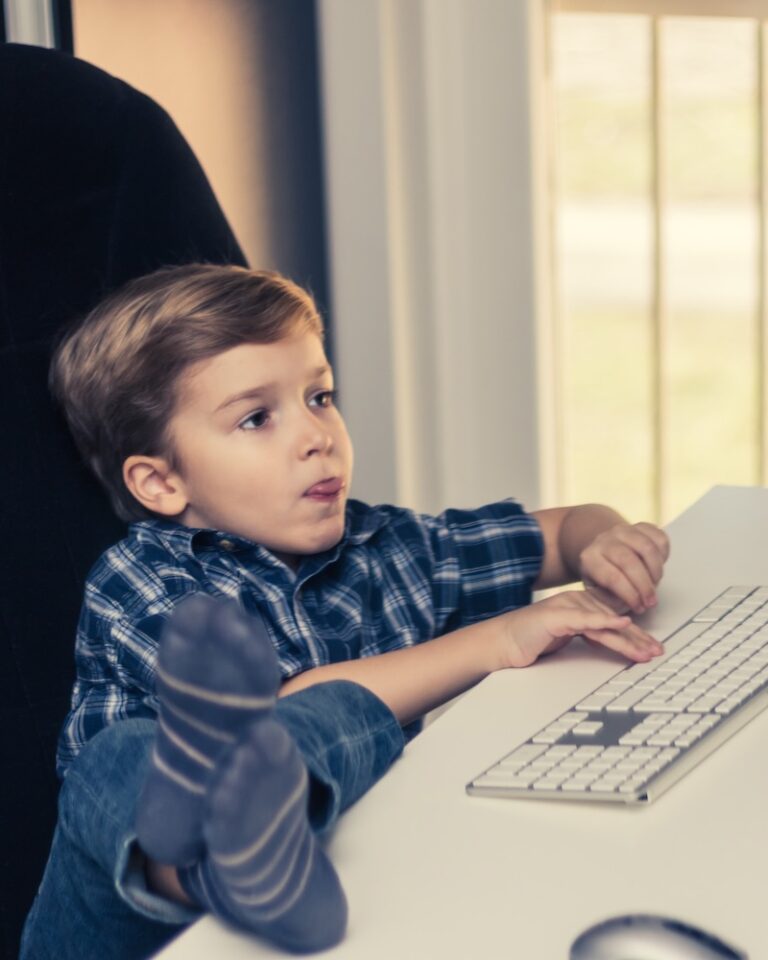 A little boy is playing computer games at home.