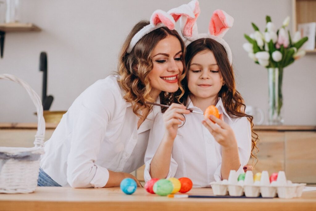 Мама и девочка разукрашивают яйца