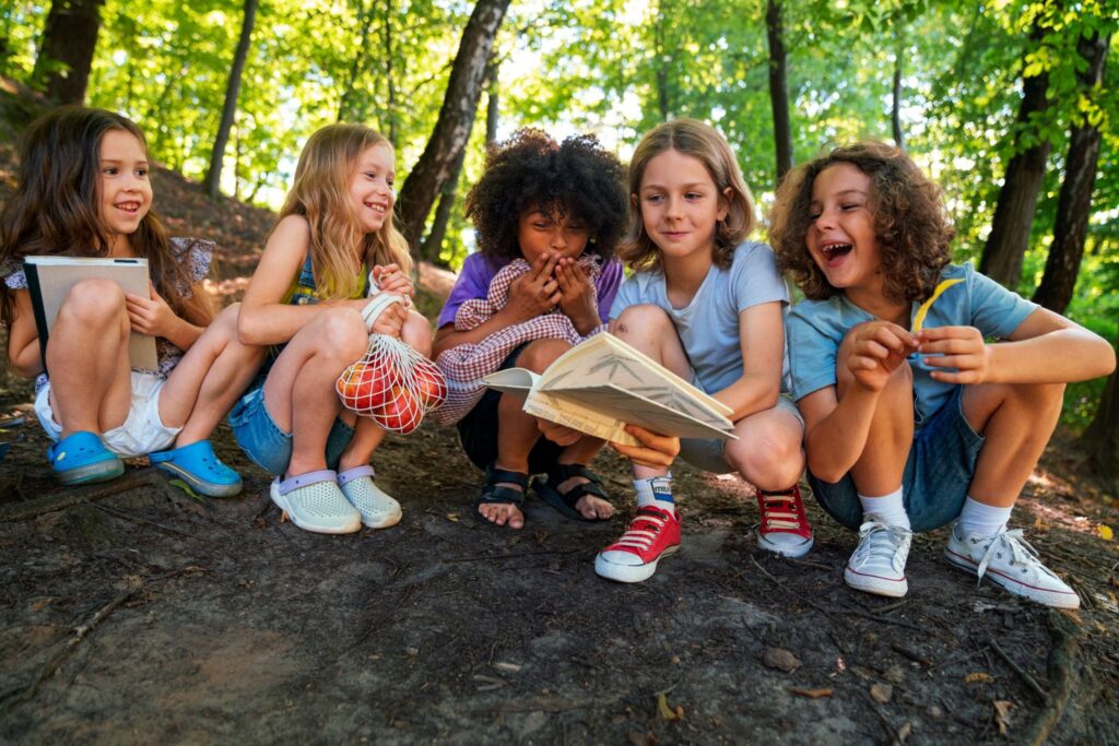 Five children are laughing, reading a book