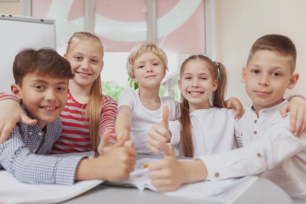 5 детей показывают класс и улыбаются