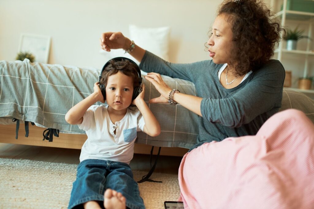 Мама и мальчик в наушниках, сидят на полу