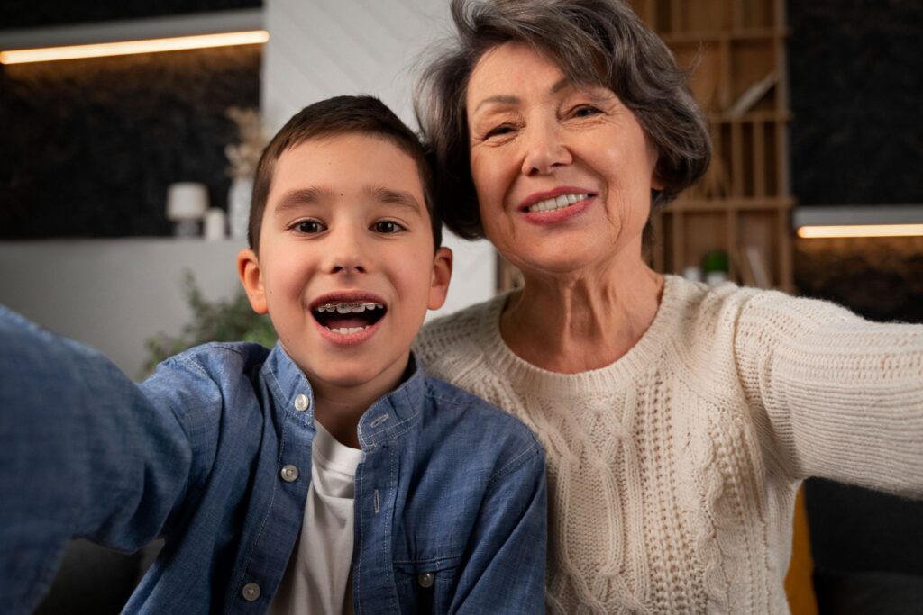 The boy and the grandmother smile for the camera