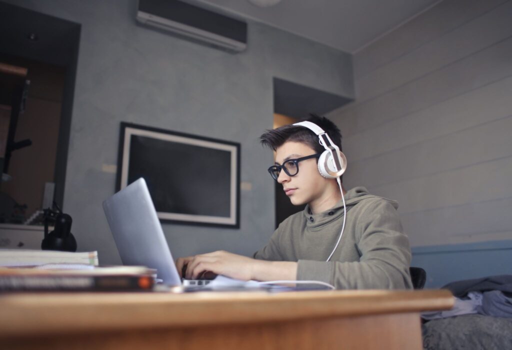 Мальчик в наушниках за ноутбуком