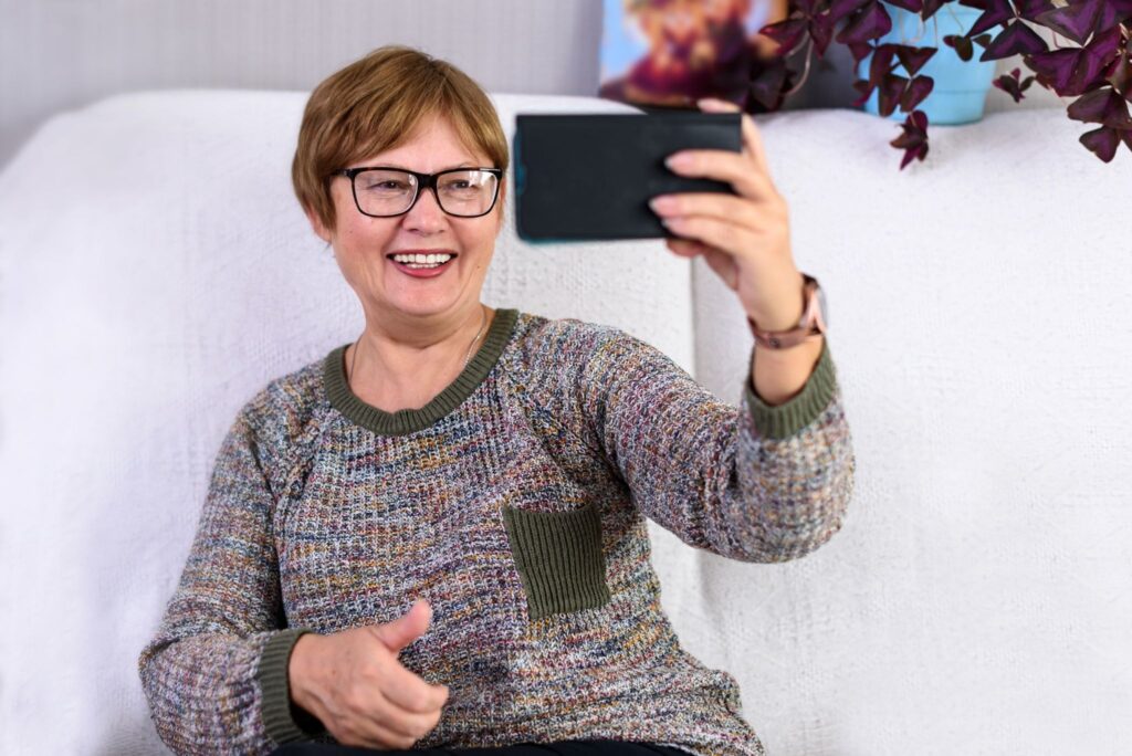 Женщина в очках держит телефон