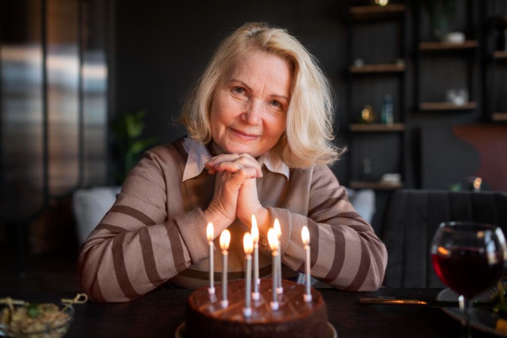 Бабушка и перед ней торт со свечами