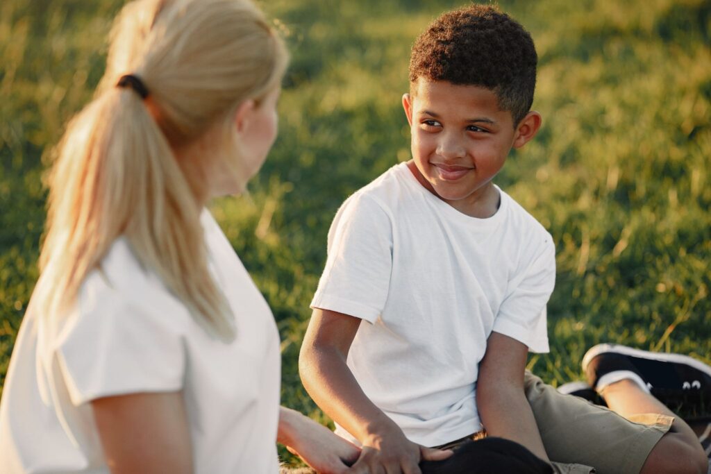Мальчик и мама сидят на поляне