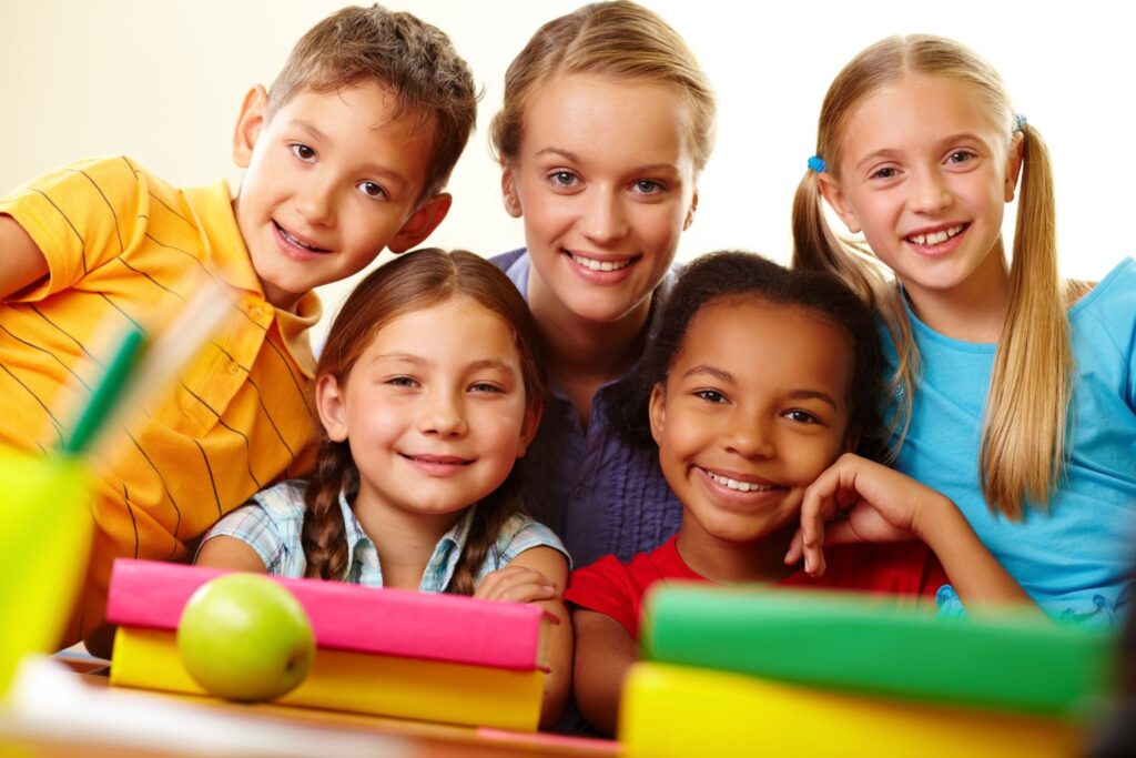 четверо детей и взрослый улыбаются