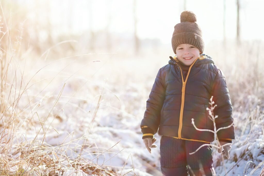 Мальчик улыбается на фоне зимнего пейзажа