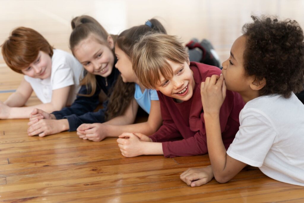 Пятеро детей смотрят друг на друга и улыбаются