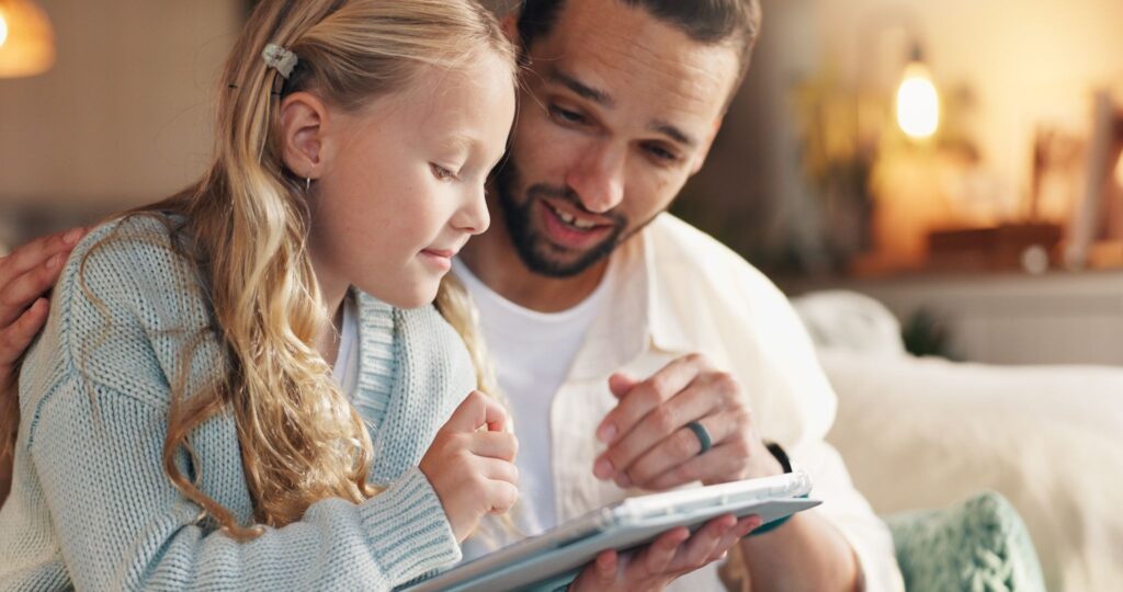 Папа и девочка смотрят что-то в блокноте