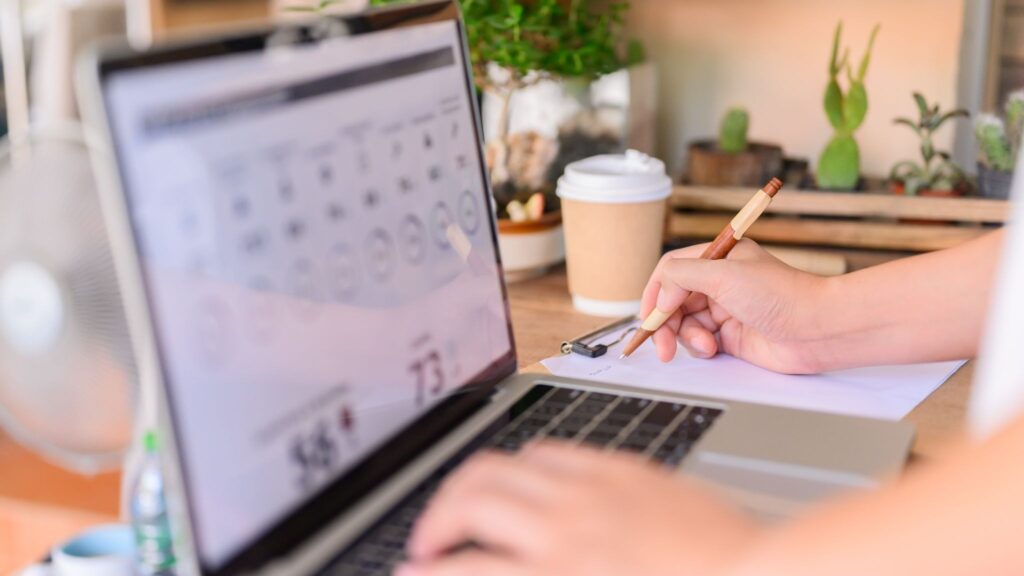 Экран ноутбука, рука с ручкой