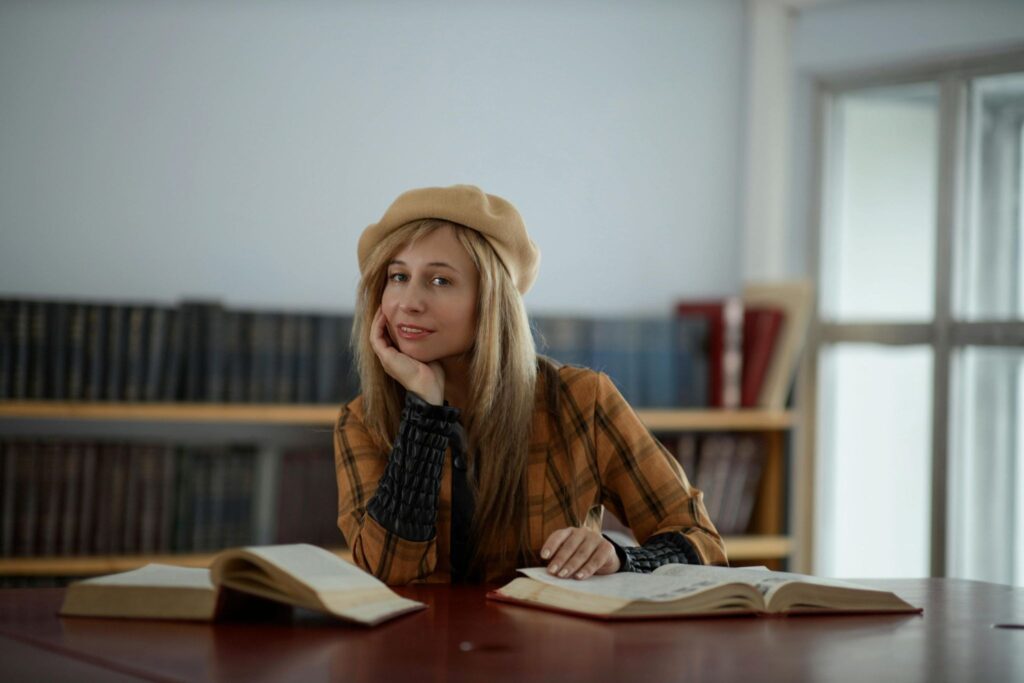 Девушка с книгами за столом в библиотеке