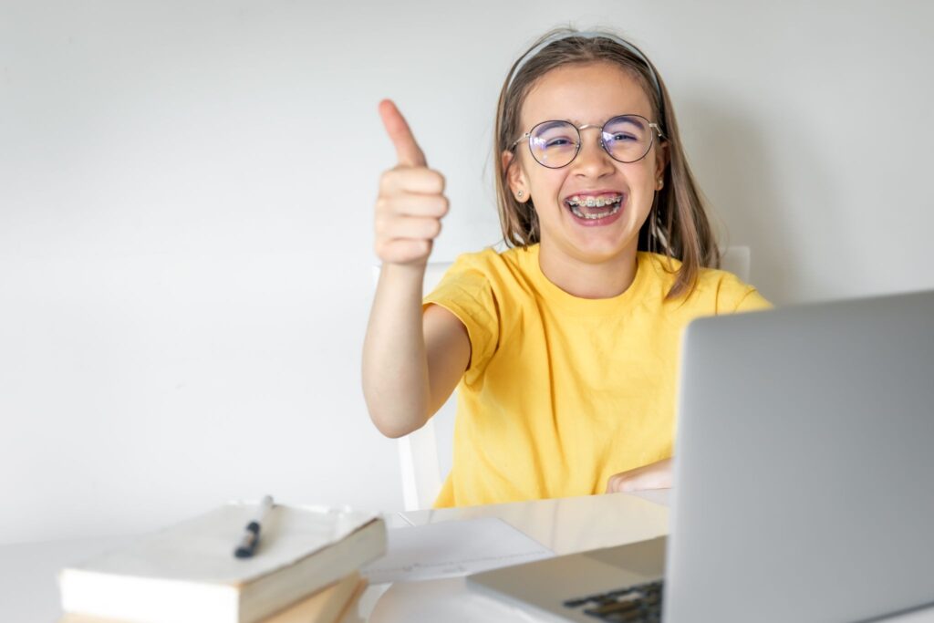 Девочка улыбается и показывает большой палец вверх
