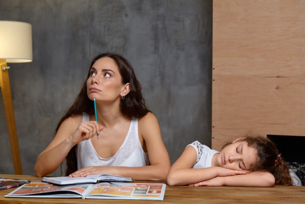 Mom with a notepad, a girl sleeps nearby on the table