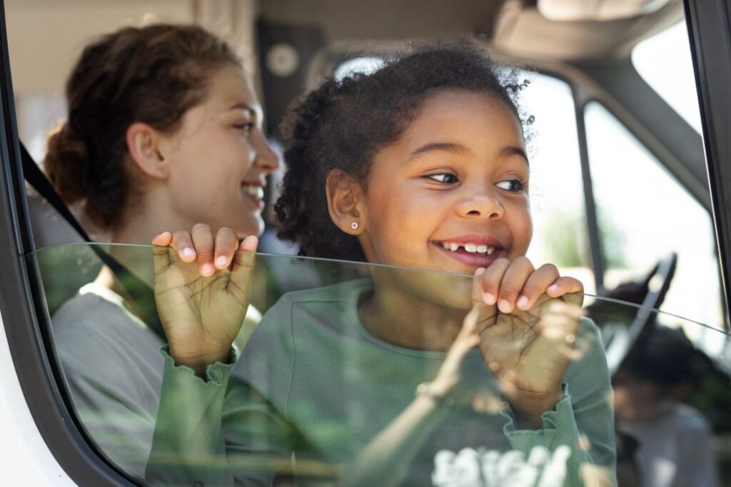 Девочка выглядывает из окна машины