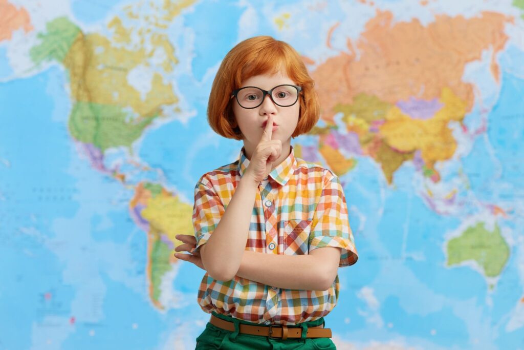 Мальчик на фоне карты, палец около рта
