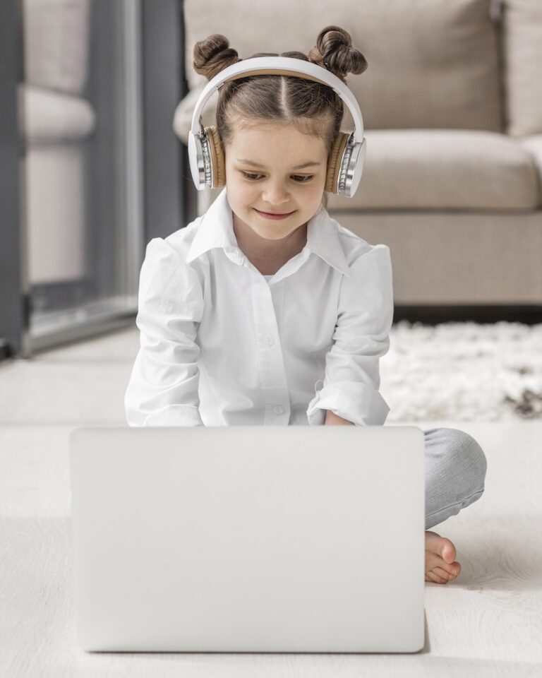 маленькая девочка слушает свою учительницу через наушники дома