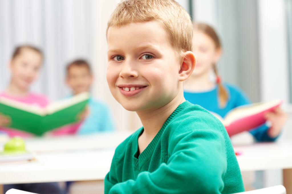 The boy smiles and looks at the camera.