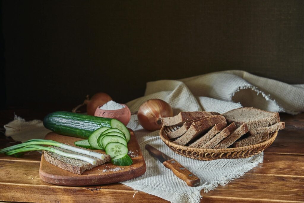 Bread in a basket, onions, cucumbers
