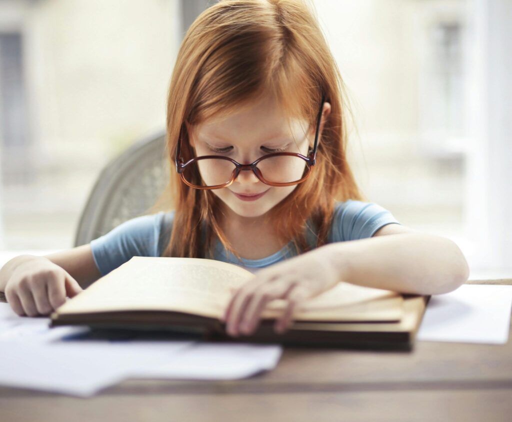 Девочка в очках читает книгу
