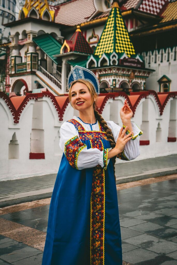 A girl in a kokoshnik and Russian sarafana against the background of a building in the form of a kremlin