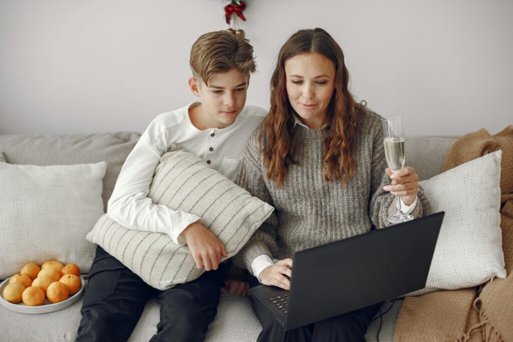 Mom and child on the couch with a laptop, looking at the screen