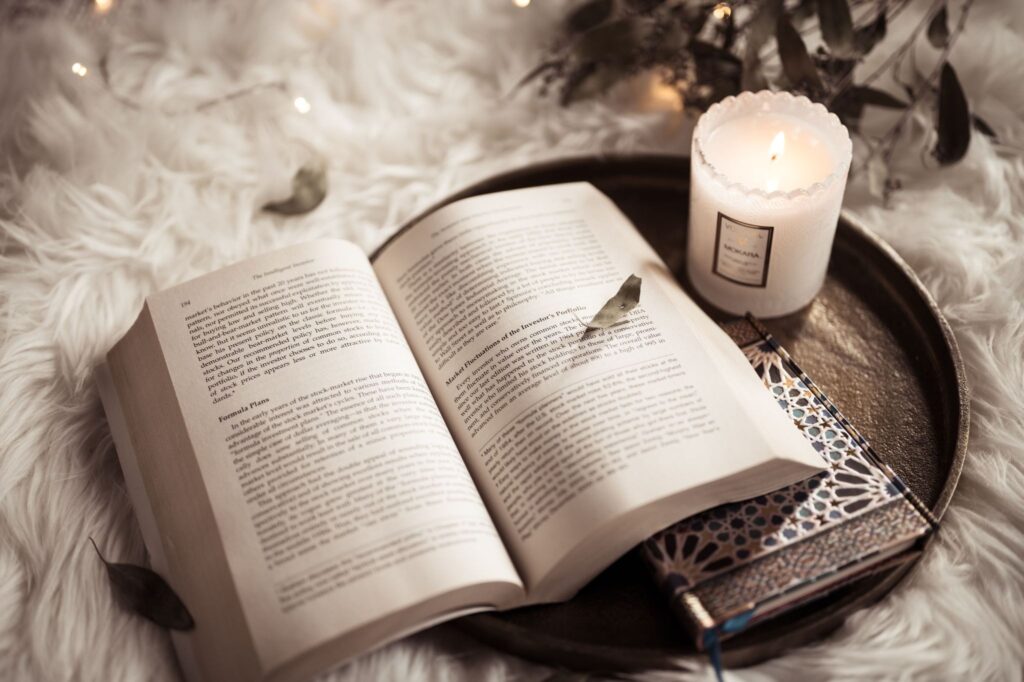 Раскрытая старинная книга при свече, образ сборника народных сказок